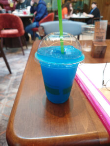 A photo of a blue ice slush drink on a wooden table