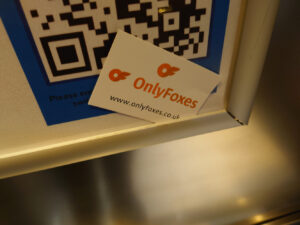 A photo of a business card tucked in to a frame that says "OnlyFoxes"