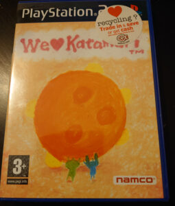A photo of We Love Katamari (PS2) Annoyingly there's a CEX sticker stuck on the top right.