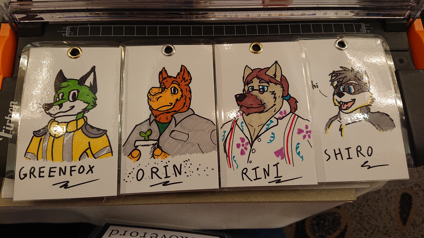 Laminated doodle badges DarkOverord did at Confuzzled 2019